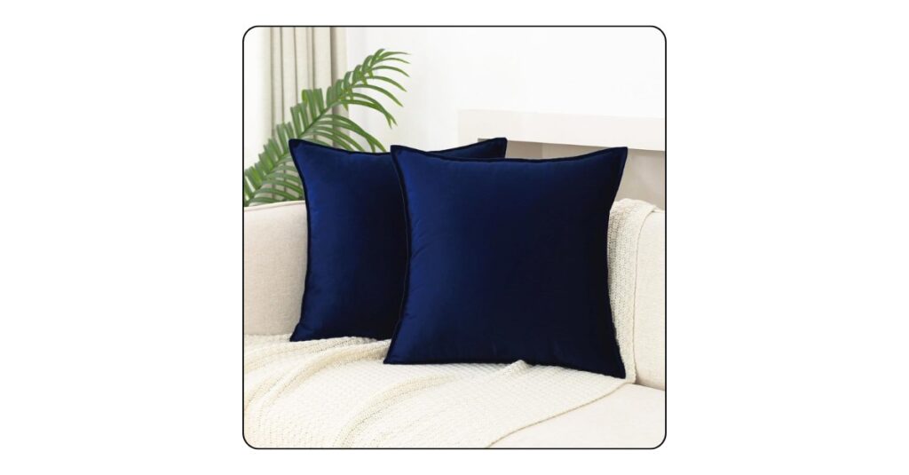Decorative throw pillows in neutral and navy tones on a luxury bed.