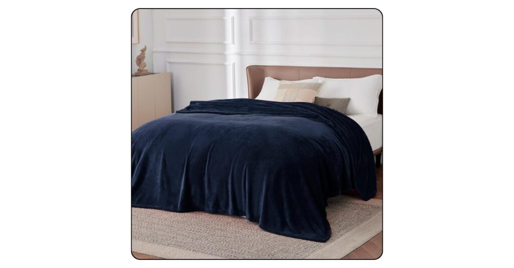Soft cozy throw blanket folded neatly on a luxury bedroom bed.